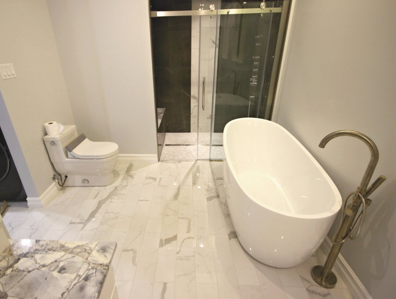 Ensuite bathroom with a curbless linear drain shower and freestanding bathtub in Ashton by Renovation to Perfection